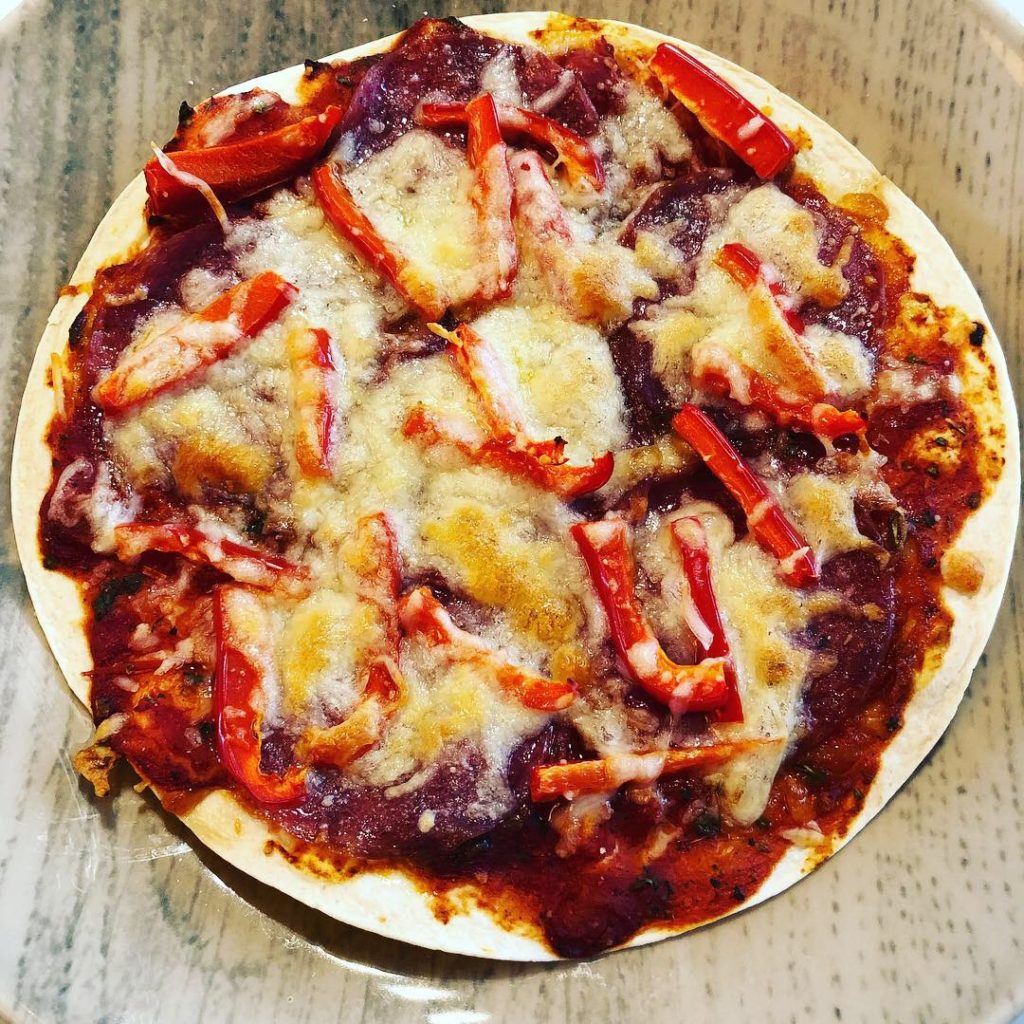 Pizza aus einem Tortillafladen belegt mit Salami,Paprika und Käse